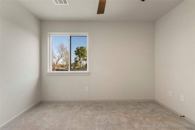 spare room featuring light carpet and ceiling fan