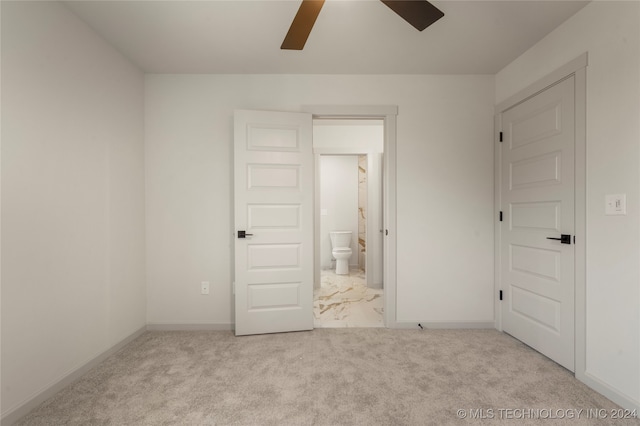 unfurnished bedroom featuring ensuite bath, ceiling fan, and light carpet