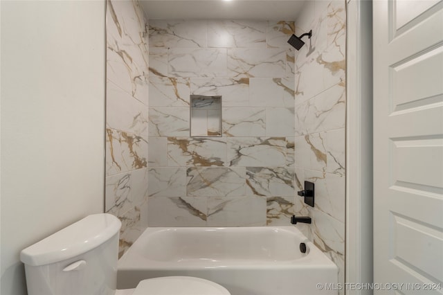 bathroom with toilet and tiled shower / bath