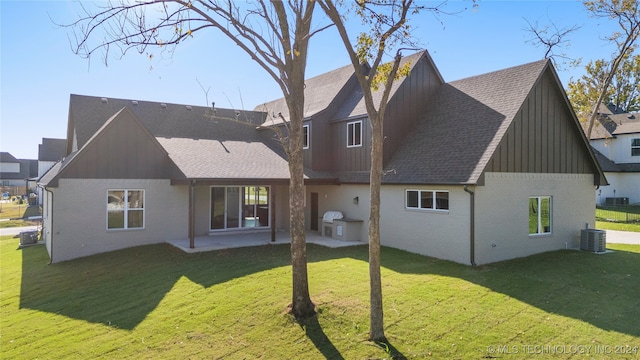 back of property with a lawn, a patio, and central AC