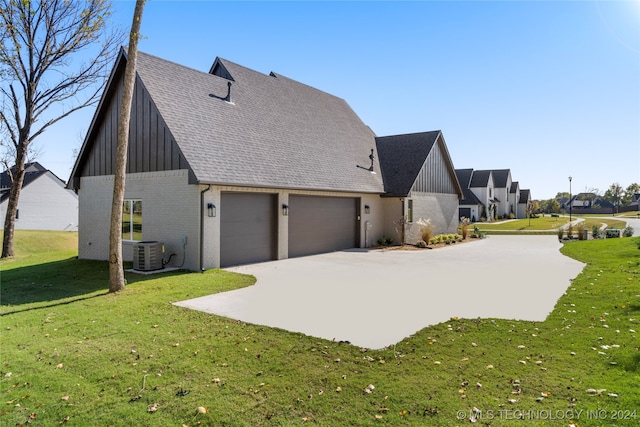 view of side of property featuring a garage, cooling unit, and a lawn