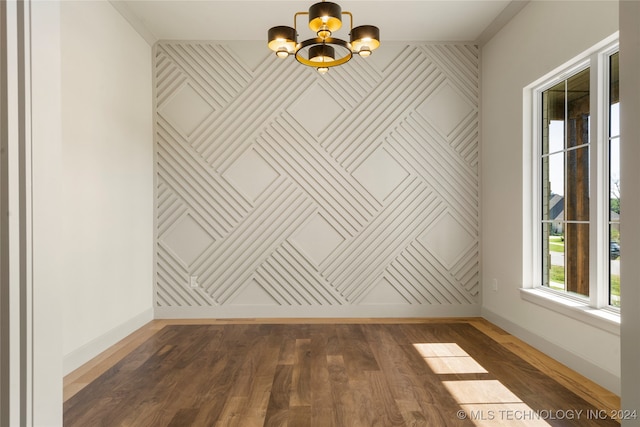 empty room featuring dark hardwood / wood-style flooring and a chandelier