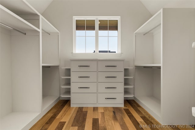 walk in closet featuring dark hardwood / wood-style flooring and vaulted ceiling