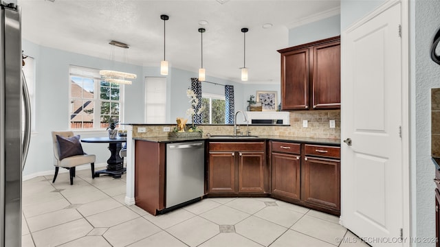 kitchen with sink, backsplash, crown molding, pendant lighting, and appliances with stainless steel finishes