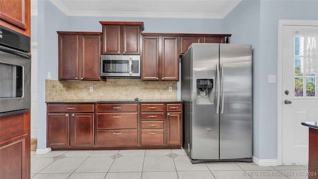 kitchen featuring light tile patterned floors, appliances with stainless steel finishes, crown molding, and tasteful backsplash