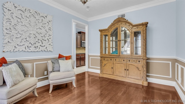 sitting room with dark hardwood / wood-style flooring and ornamental molding