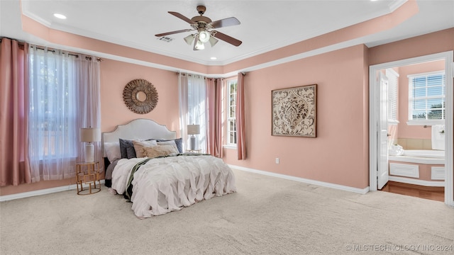 carpeted bedroom with a tray ceiling, ceiling fan, and crown molding