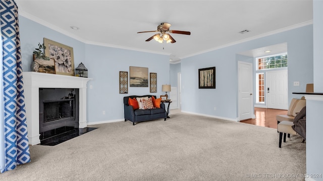 living area featuring carpet, ceiling fan, and crown molding