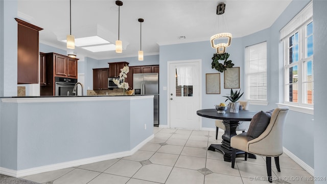 kitchen with hanging light fixtures, crown molding, stainless steel appliances, and a notable chandelier