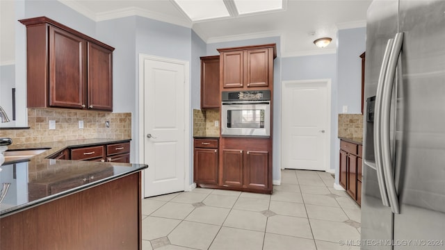 kitchen featuring sink, stainless steel appliances, backsplash, crown molding, and dark stone counters