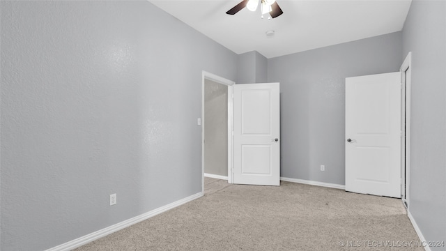 unfurnished bedroom with light colored carpet and ceiling fan