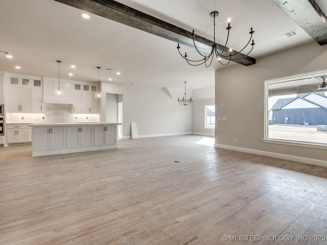 unfurnished living room featuring light hardwood / wood-style floors and a notable chandelier