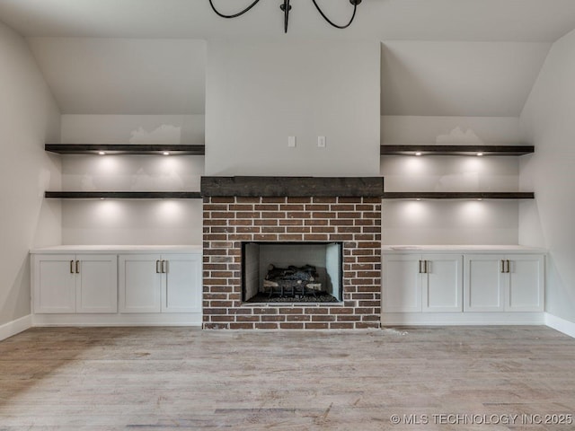 unfurnished living room with a fireplace and light wood-type flooring