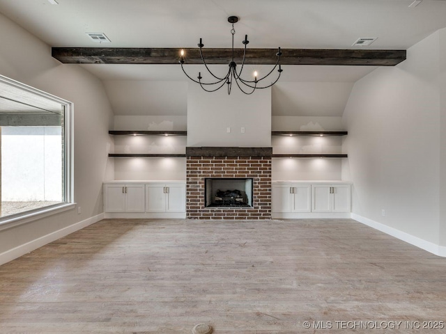 unfurnished living room with a brick fireplace, a chandelier, built in features, and light wood-type flooring