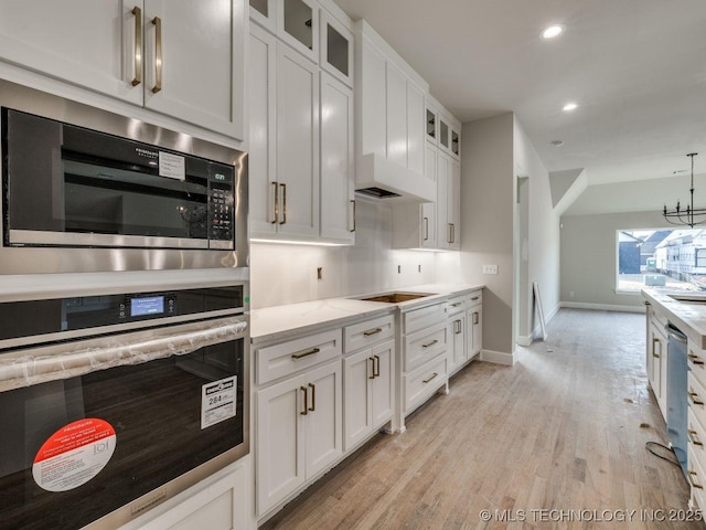 kitchen featuring white cabinetry, appliances with stainless steel finishes, and light stone counters