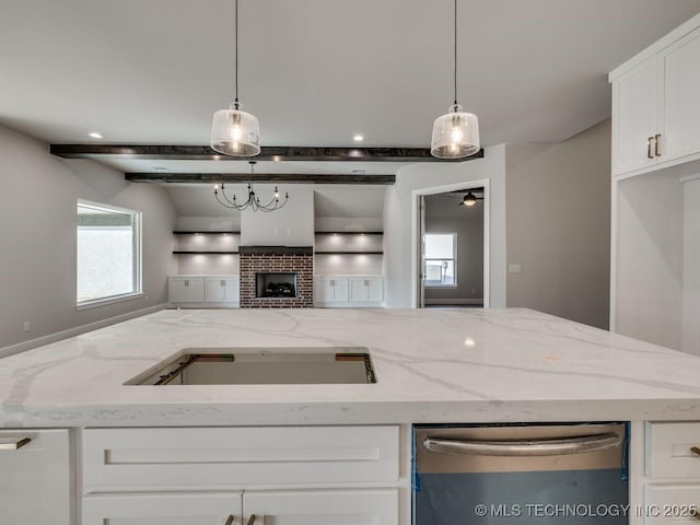 kitchen with light stone counters, stainless steel dishwasher, pendant lighting, a fireplace, and white cabinets