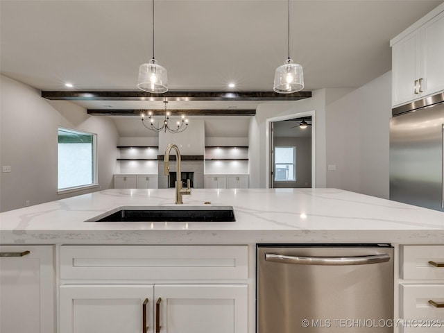 kitchen with a ceiling fan, light stone counters, a sink, stainless steel appliances, and white cabinets