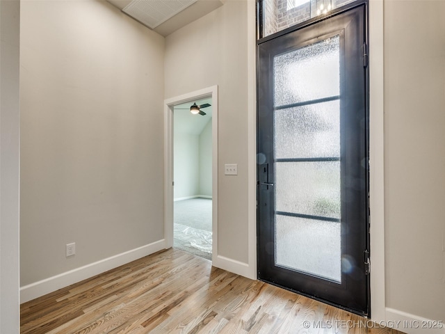entrance foyer with a ceiling fan, baseboards, a healthy amount of sunlight, and wood finished floors