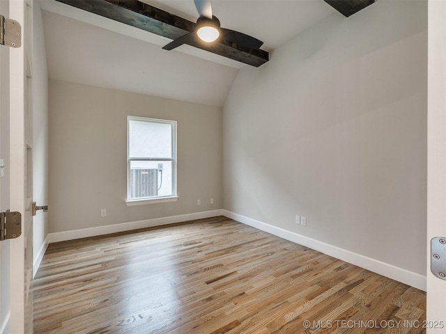 spare room with wood finished floors, vaulted ceiling with beams, baseboards, and a ceiling fan
