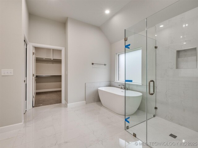 bathroom featuring marble finish floor, baseboards, a freestanding bath, and a marble finish shower