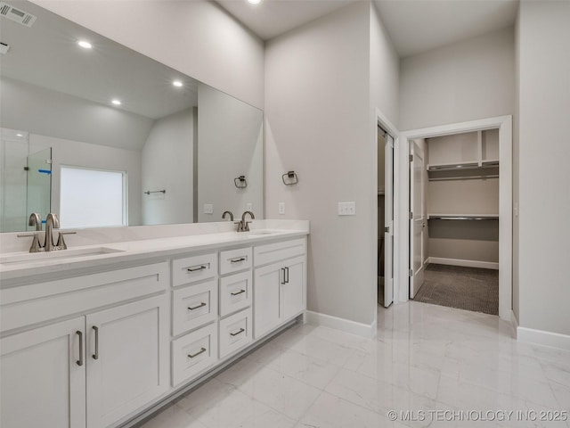 full bath with marble finish floor, double vanity, visible vents, a sink, and baseboards