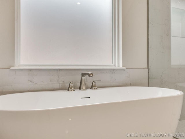 full bathroom with a freestanding tub and a sink