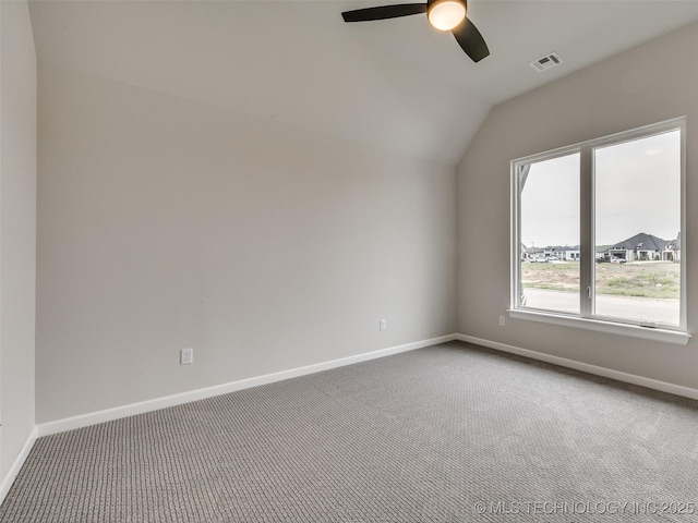 carpeted empty room with vaulted ceiling, visible vents, baseboards, and ceiling fan