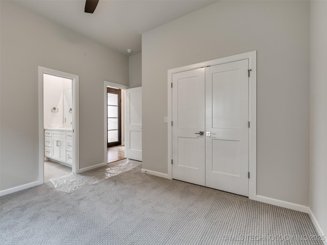 unfurnished bedroom with a closet, baseboards, and light carpet