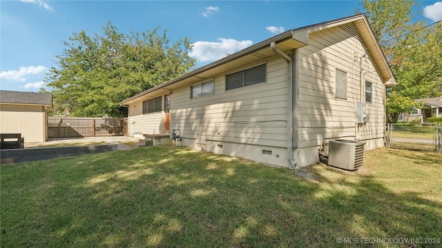 view of side of property featuring a yard and cooling unit