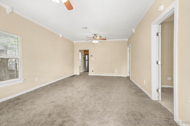 carpeted spare room featuring crown molding and ceiling fan