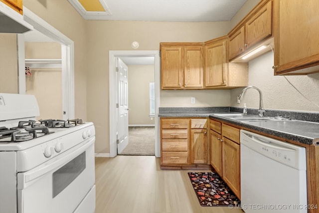 kitchen featuring white appliances, light hardwood / wood-style floors, and sink