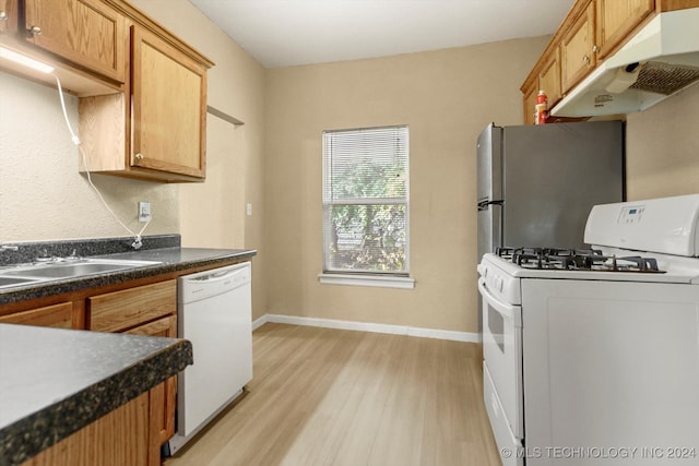 kitchen featuring white appliances, light hardwood / wood-style floors, and sink