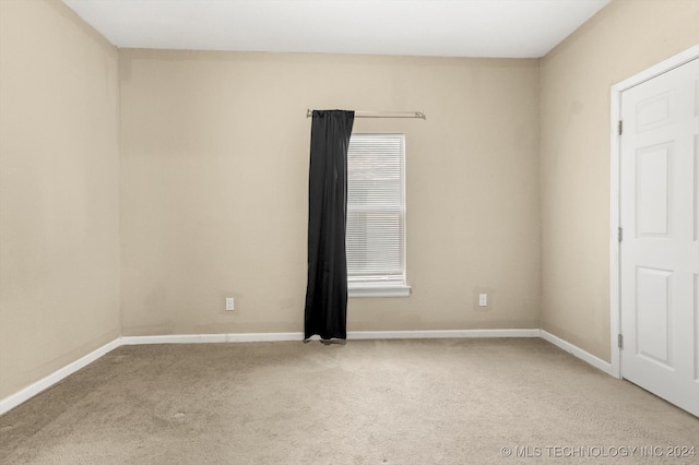 spare room featuring light carpet