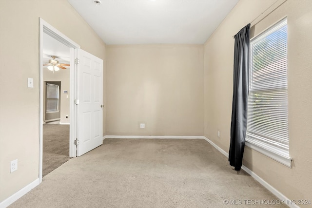 carpeted spare room with ceiling fan