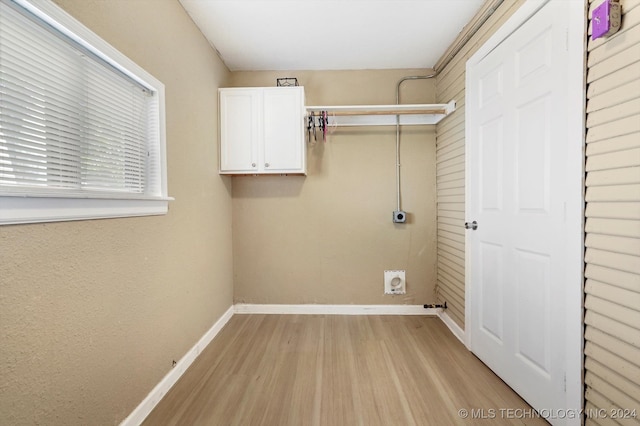 laundry area featuring cabinets, light hardwood / wood-style floors, and hookup for an electric dryer