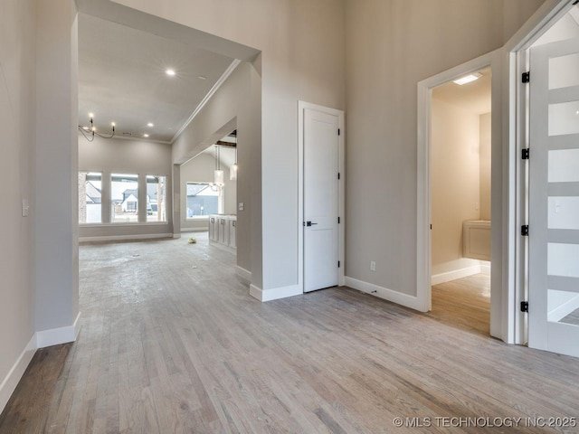 hallway with ornamental molding and light wood-type flooring