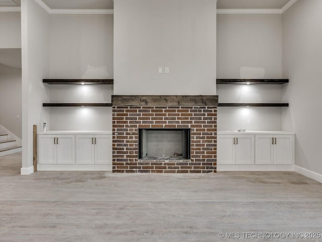 unfurnished living room featuring ornamental molding, light hardwood / wood-style floors, and a brick fireplace