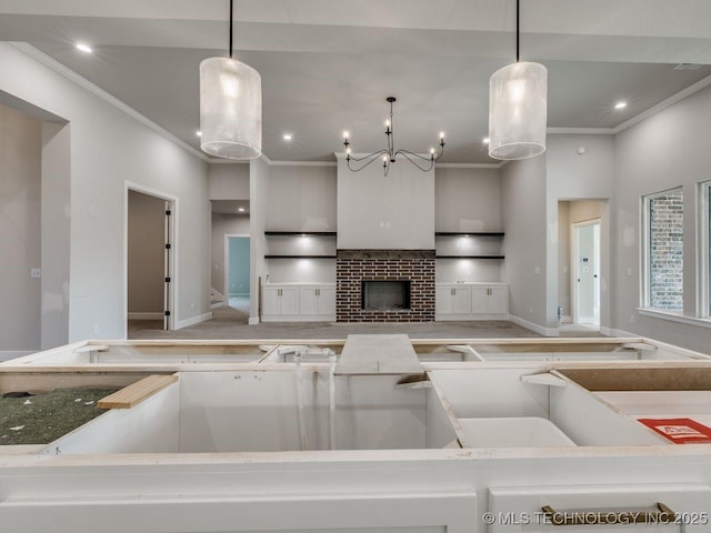 kitchen featuring crown molding, a brick fireplace, and hanging light fixtures