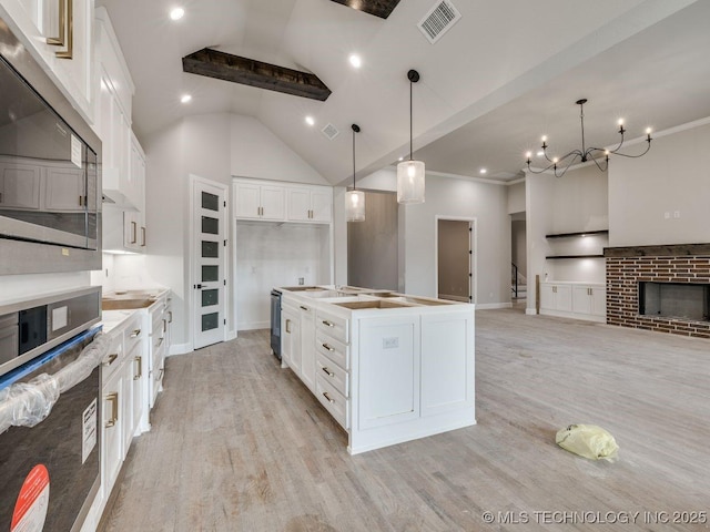 kitchen featuring a kitchen island with sink, high vaulted ceiling, light hardwood / wood-style floors, white cabinets, and oven