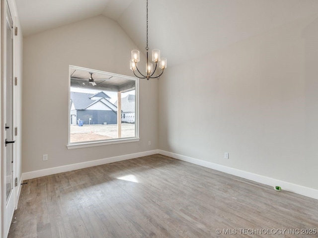 empty room with lofted ceiling, hardwood / wood-style floors, and ceiling fan