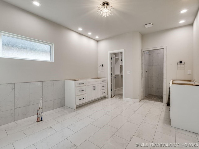 bathroom featuring vanity and tiled shower