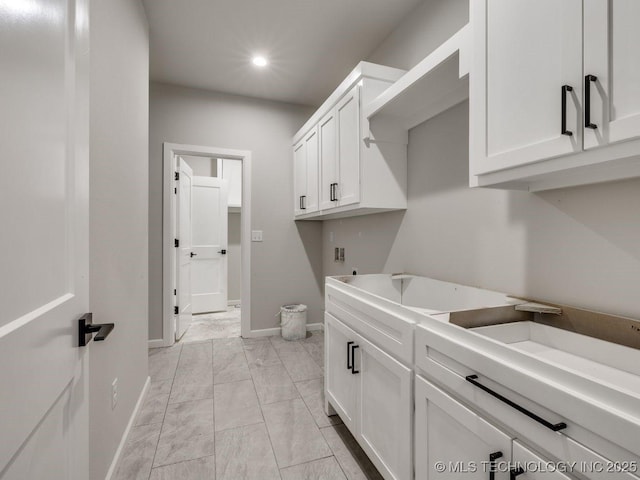 laundry room featuring washer hookup, sink, and cabinets