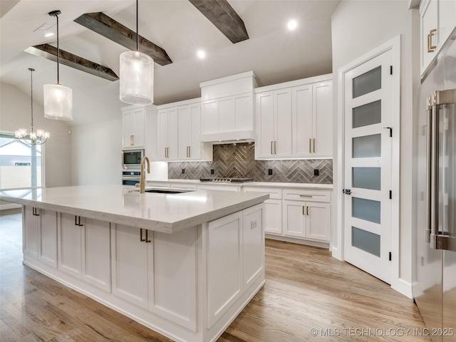 kitchen featuring tasteful backsplash, beam ceiling, stainless steel appliances, and a sink