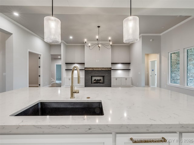 kitchen with crown molding, light stone countertops, and a sink