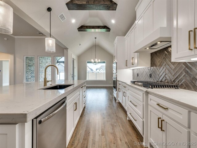 kitchen with custom exhaust hood, a sink, a kitchen island with sink, appliances with stainless steel finishes, and white cabinetry