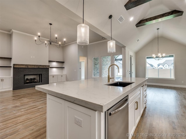 kitchen featuring stainless steel dishwasher, a sink, an inviting chandelier, light wood-style flooring, and visible vents