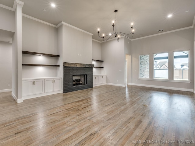 unfurnished living room featuring a high ceiling, crown molding, a chandelier, and light wood-style floors