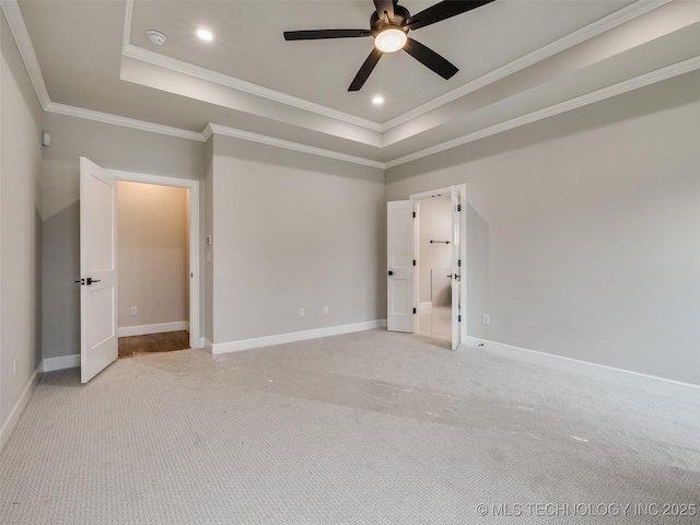 unfurnished bedroom featuring light carpet, ornamental molding, a tray ceiling, and baseboards