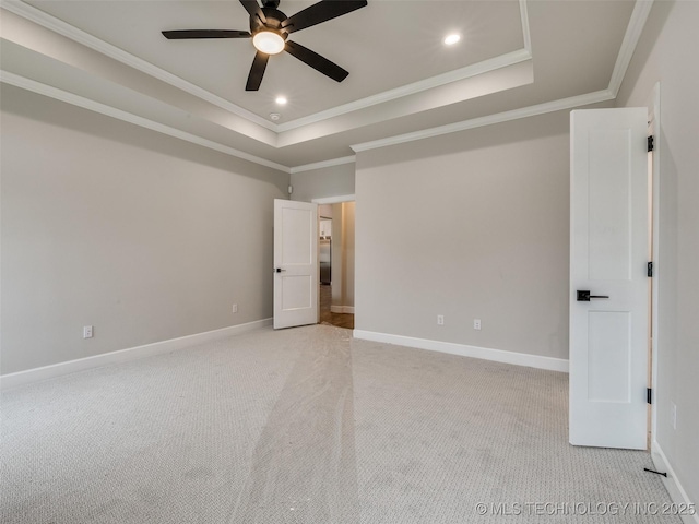 unfurnished bedroom with baseboards, recessed lighting, light colored carpet, crown molding, and a raised ceiling
