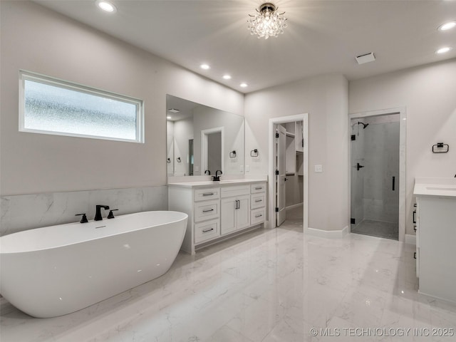 full bath featuring recessed lighting, marble finish floor, a freestanding bath, vanity, and a stall shower